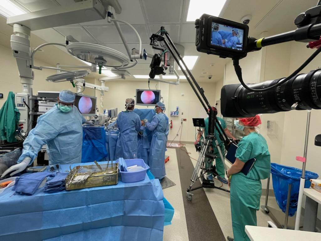 Broadcast team filming a live surgical procedure in an operating room
